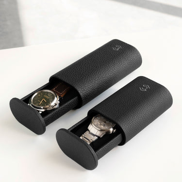 Lifestyle photo of two Oscar watch rolls in black leather side by side. The Oscar 1 Tall for watches with a watch strap on the left and the Oscar 1 for watches with a metal bracelet on the right