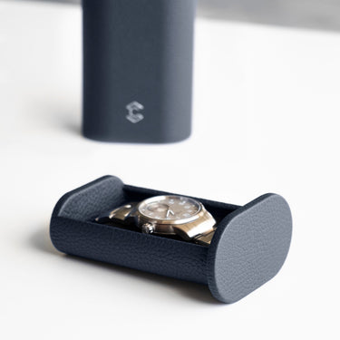 Closeup lifestyle photo of Oscar 1 Watch roll case in marine leather holding a men's watch with a metal bracelet.