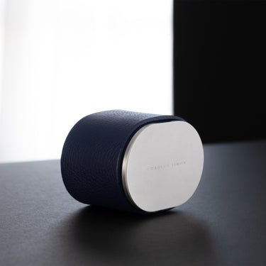 Lifestyle photo of closed Theo Watch roll in sapphire leather and grey anodized aluminum. Handmade in Canada.